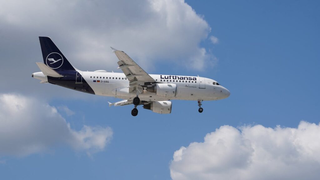 A Lufthansa jet cruising through blue skies above Hamburg, Germany.
